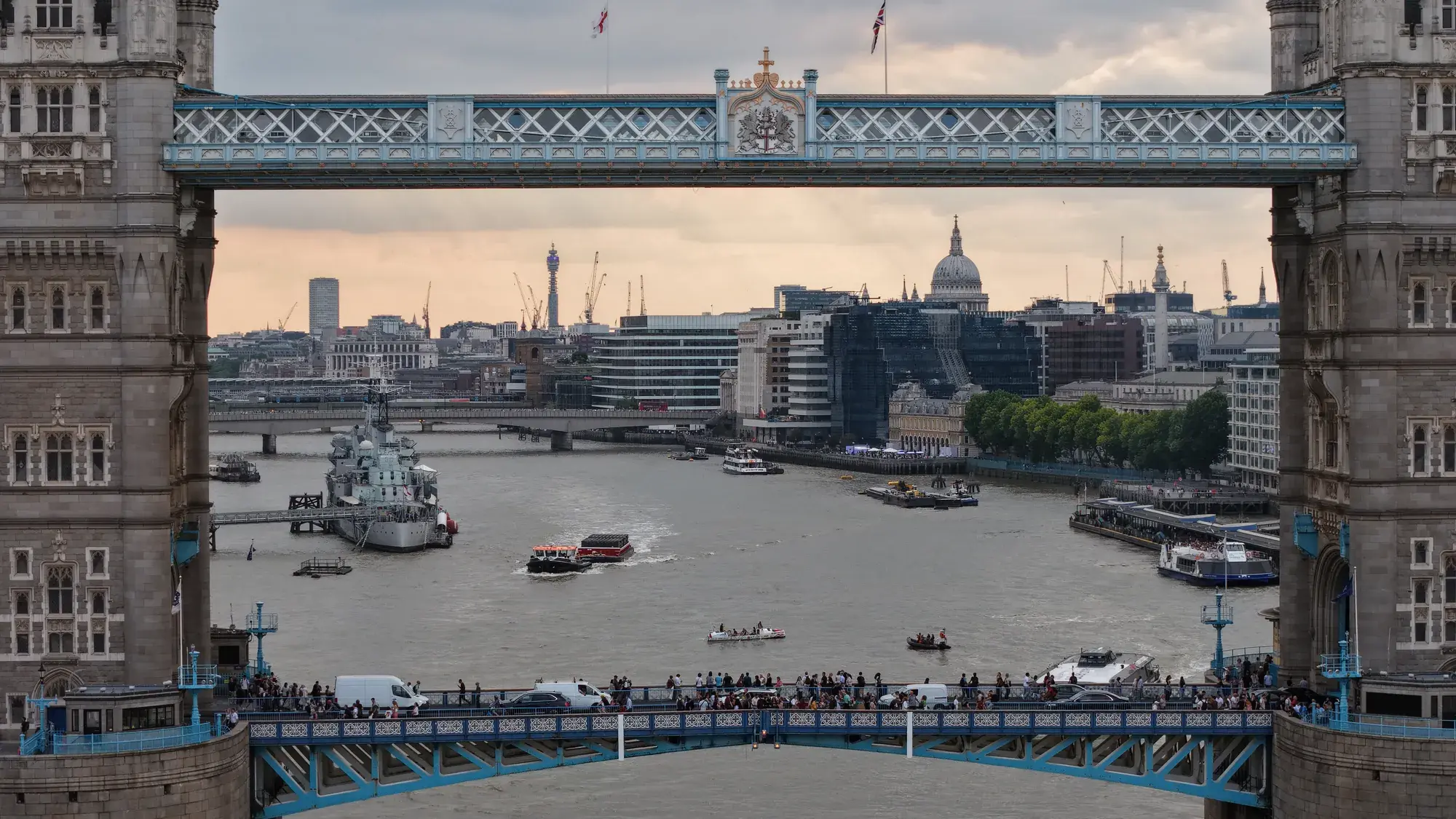 Aerial photograph framing the City of London through Tower Bridge's high-level walkways