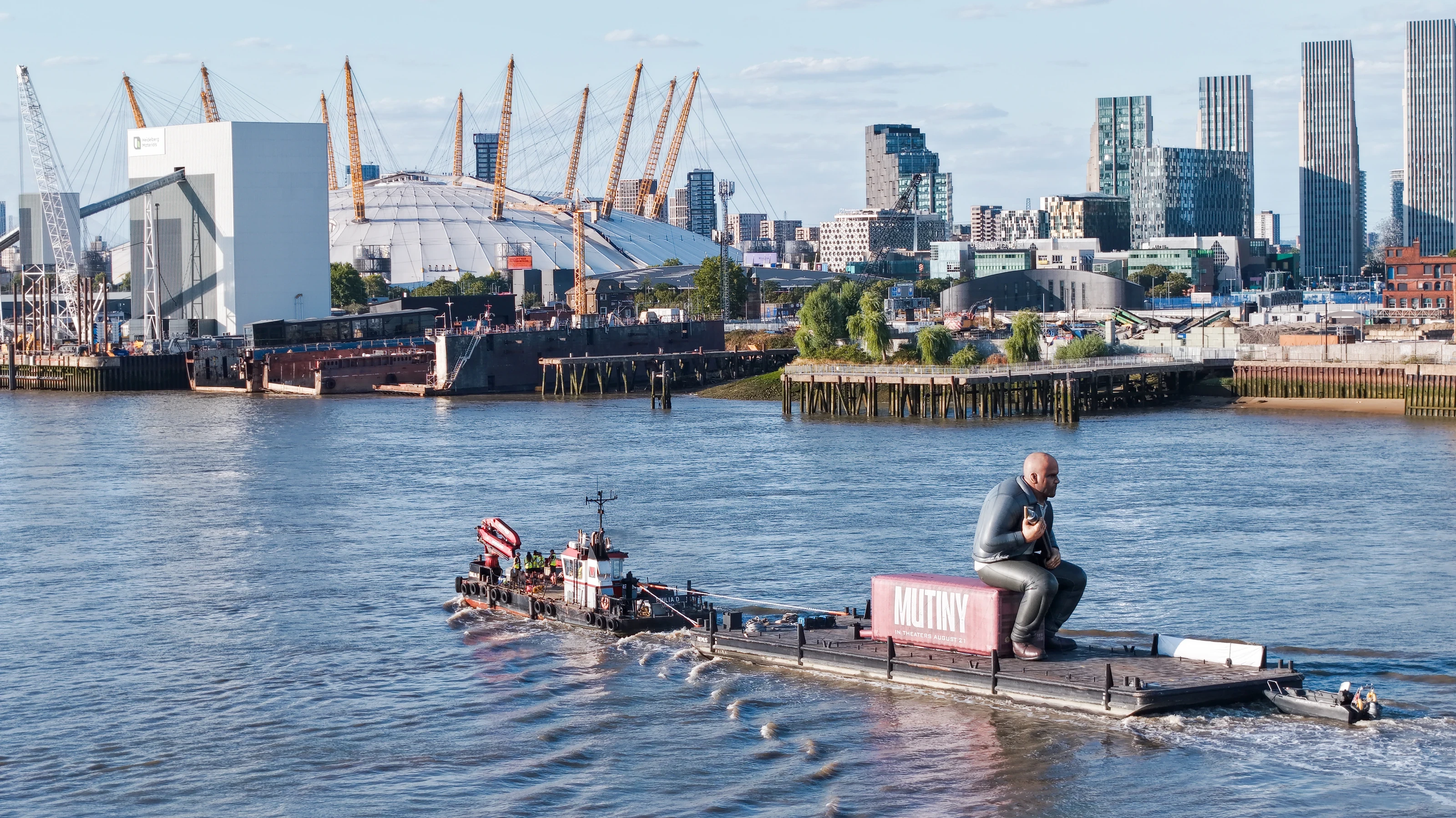 The Damen multicat Emilia D towing the Mutiny pontoon through Bugsby's Reach on the tidal Thames, with a safety boat in attendance