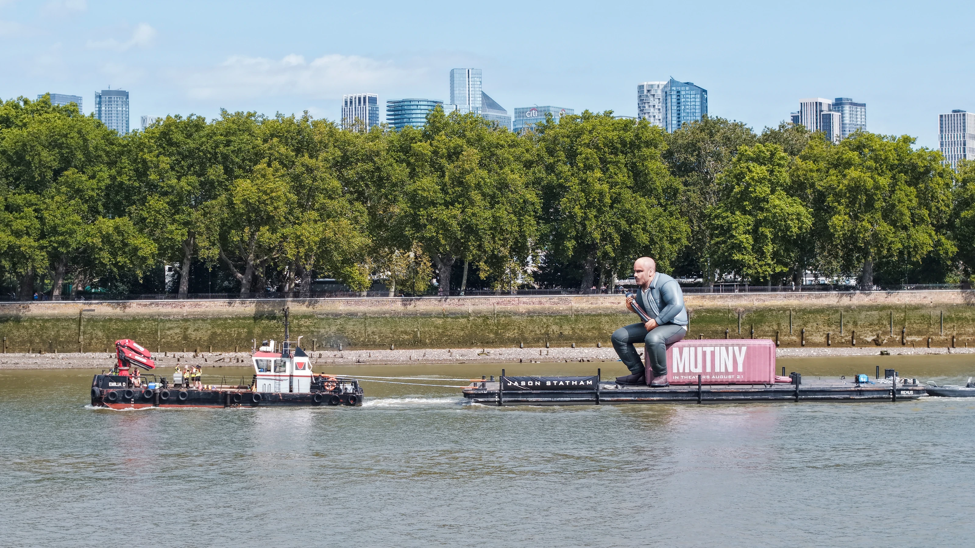 Aerial view of the Mutiny brand activation passing Island Gardens on the Isle of Dogs, with the Canary Wharf skyline beyond.