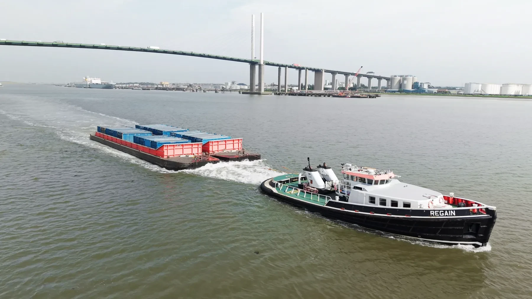 Cory Group tug moving waste containers along the River Thames, aerial drone photograph