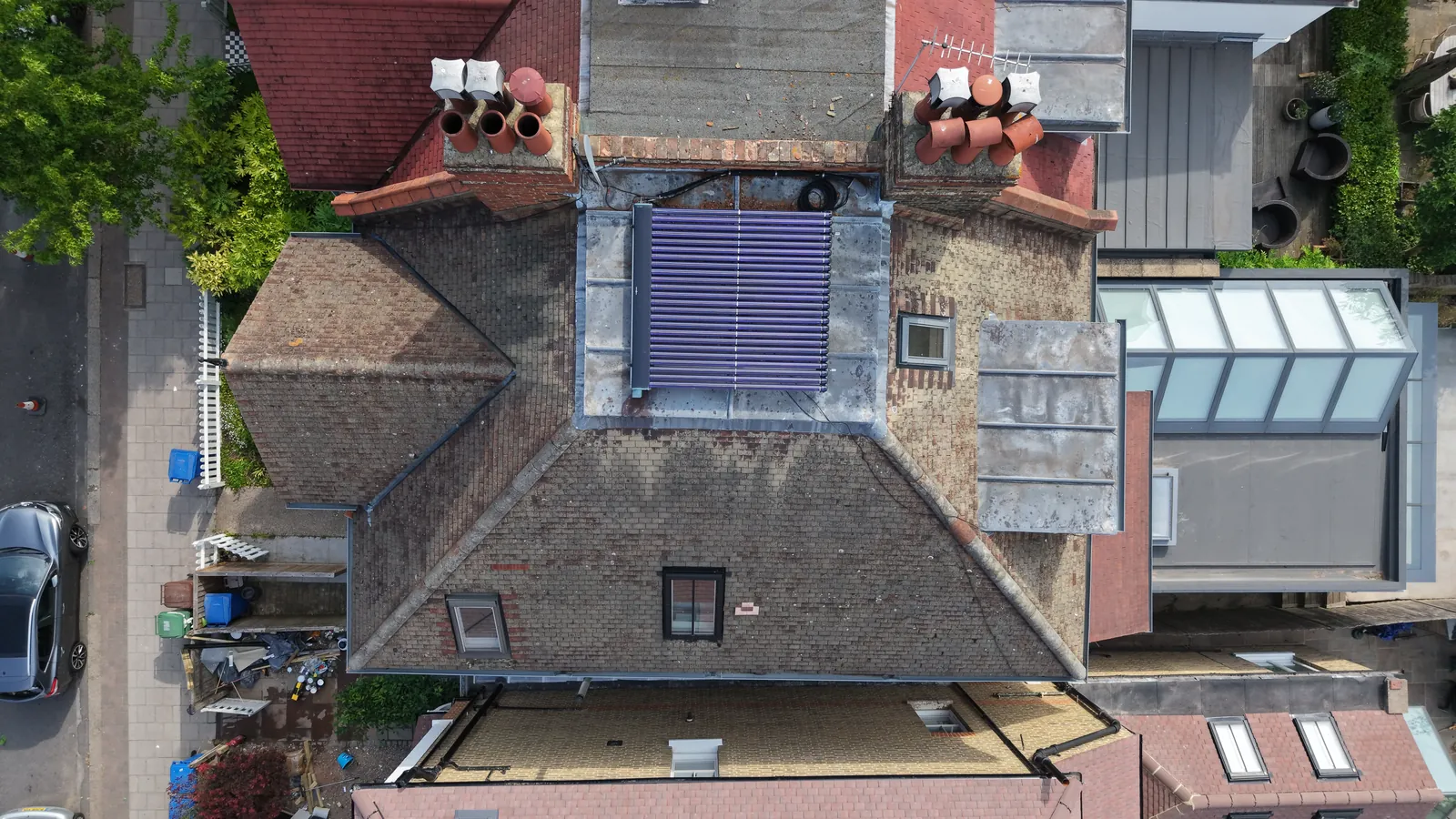 Drone roof inspection over a London home showing solar panels, tiles and dormer condition
