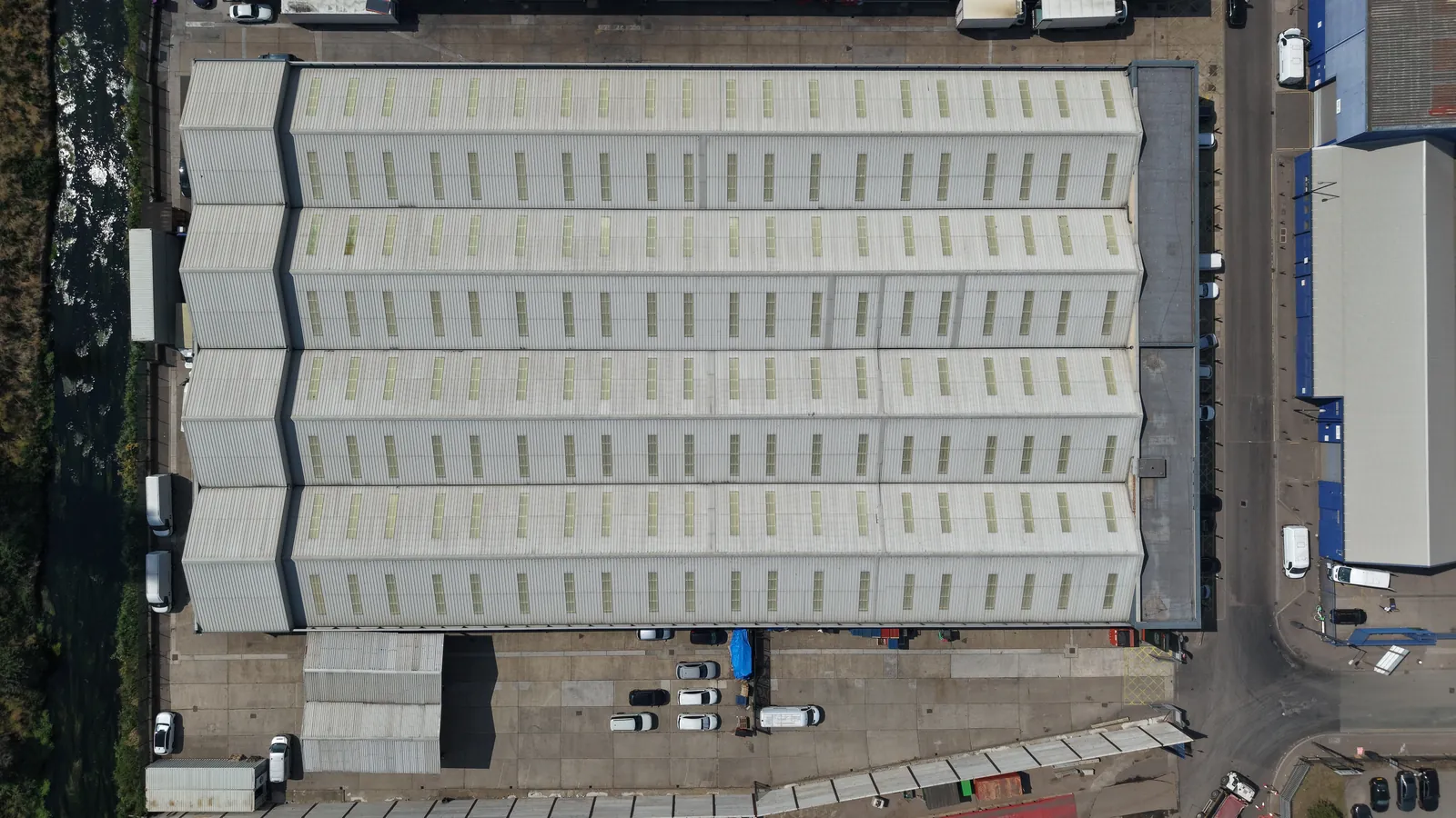 Top-down drone survey image of a London warehouse roof showing rooflights and cladding condition