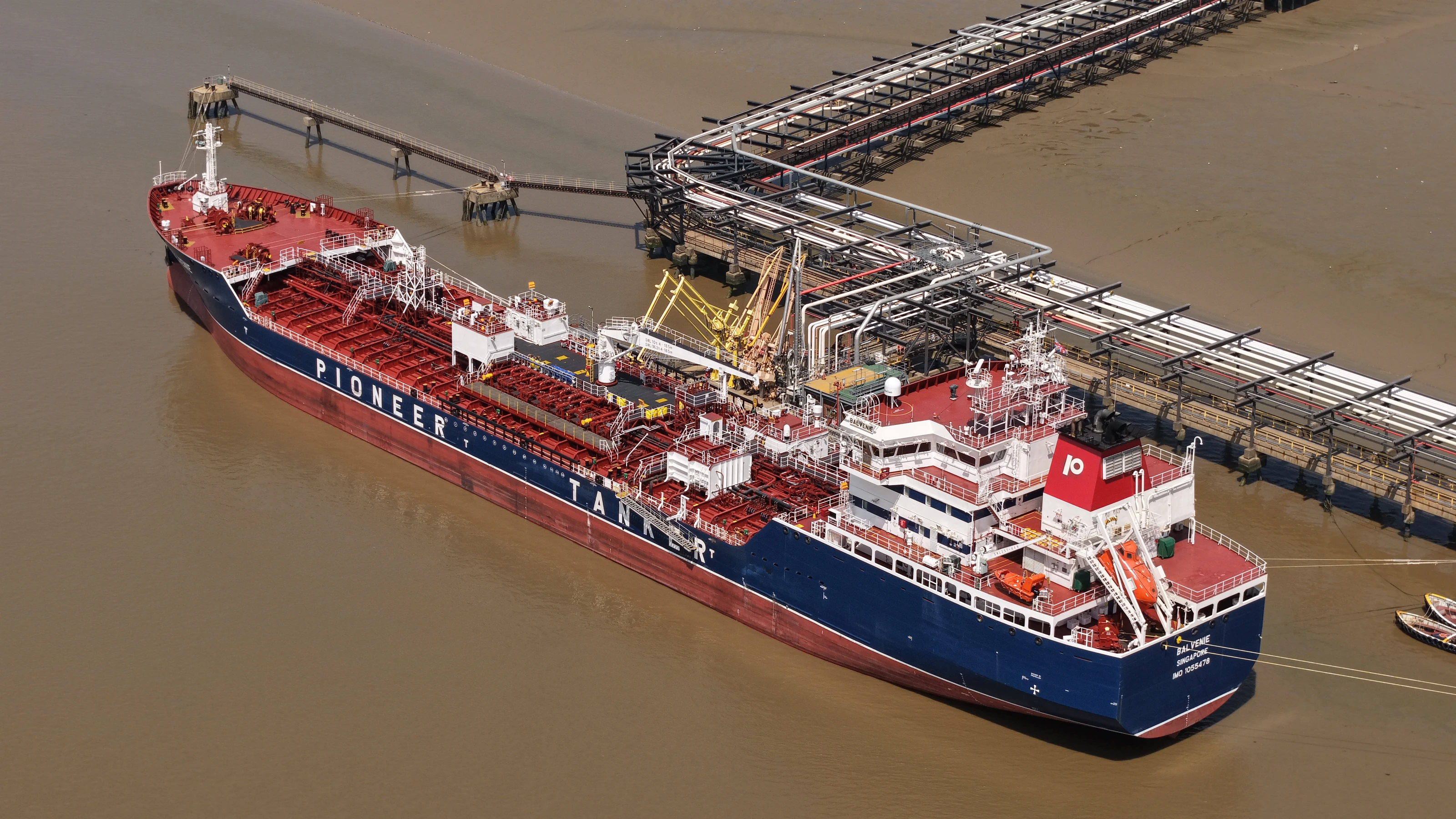 The product tanker Balvenie alongside an oil terminal jetty on the lower Thames, loading arms connected and the cargo manifold visible.