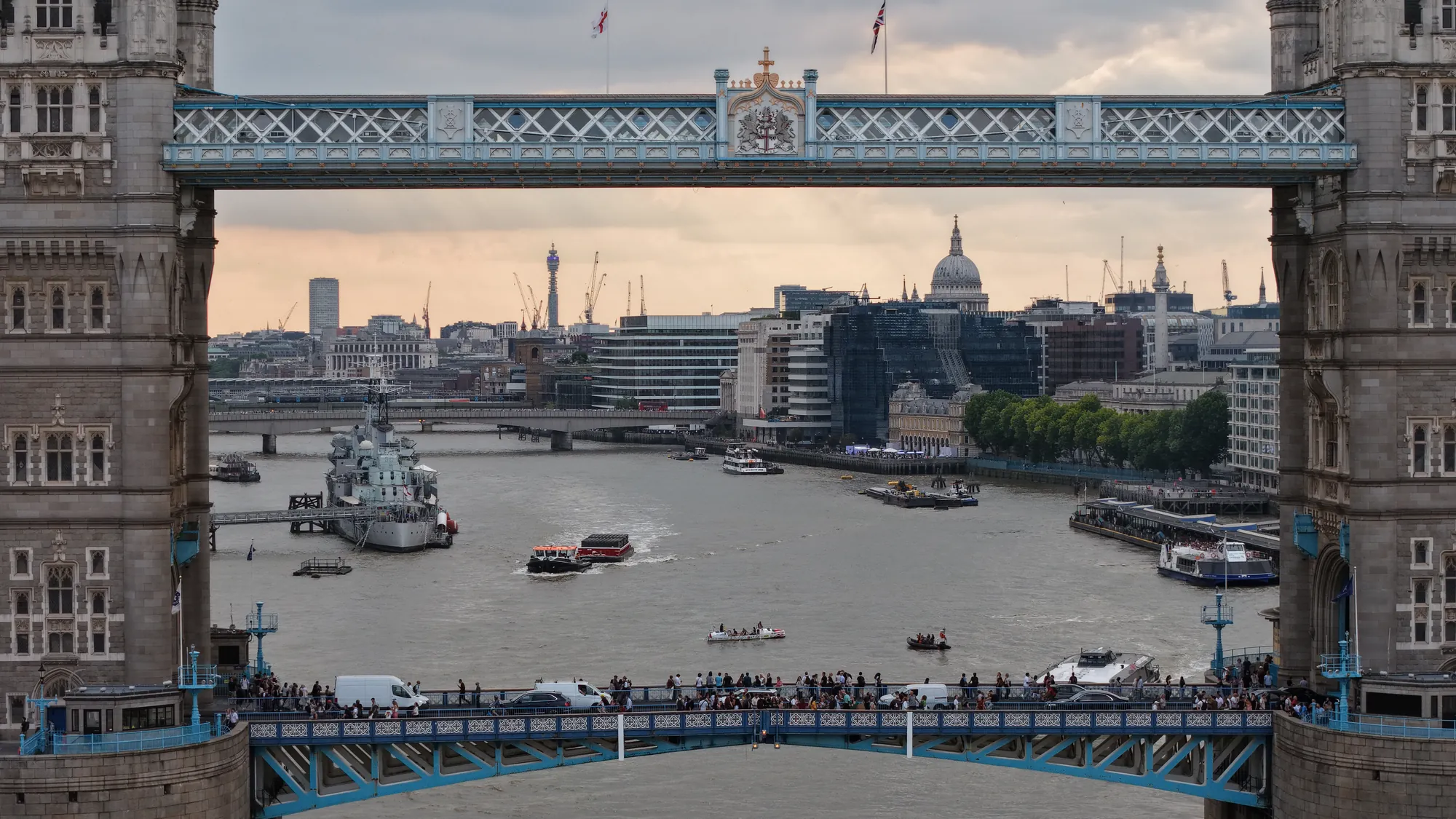 Aerial photograph framing the City of London through Tower Bridge's high-level walkways.