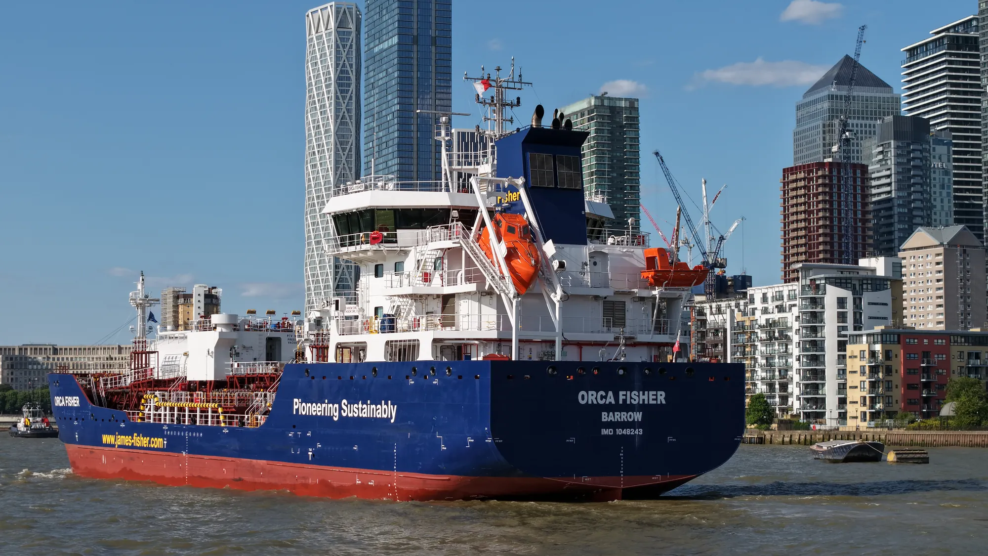Close aerial view of the James Fisher tanker Orca Fisher with One Canada Square and Canary Wharf behind
