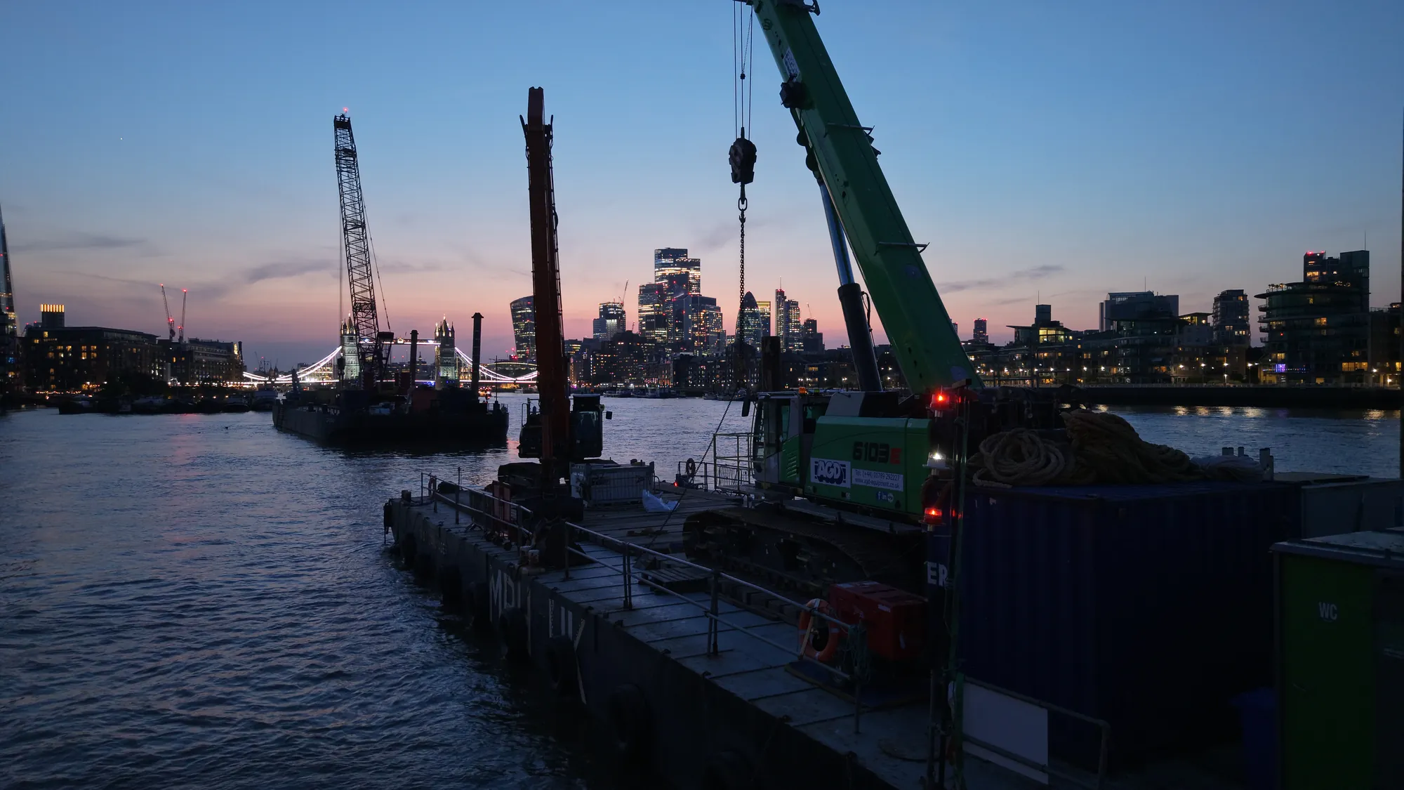 MPH UK spud-leg pontoon jacked up on the River Thames at twilight, aerial drone photograph.